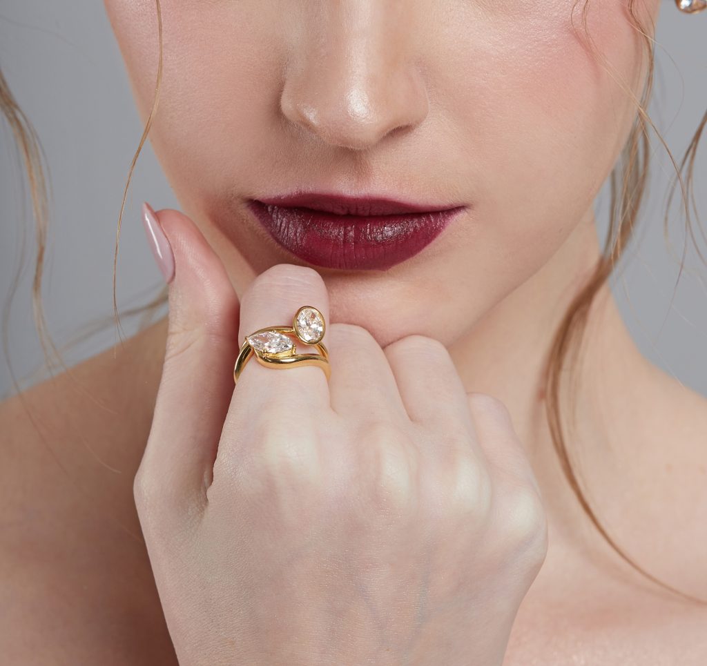 Close-up of model’s lips and fingers wearing elegant diamond ring